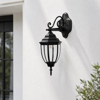 Traditional black metal outdoor wall lantern for porch entrance driveway and exterior walls with warm ambient lighting.