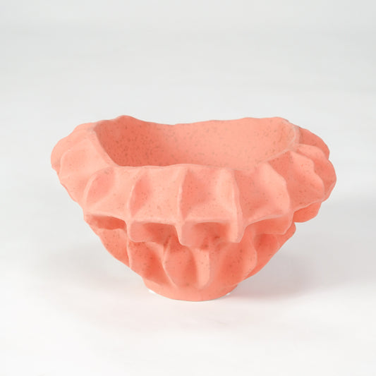 Pink textured ceramic bowl for modern coffee table placement and stylish indoor home decor styling accent centerpiece.