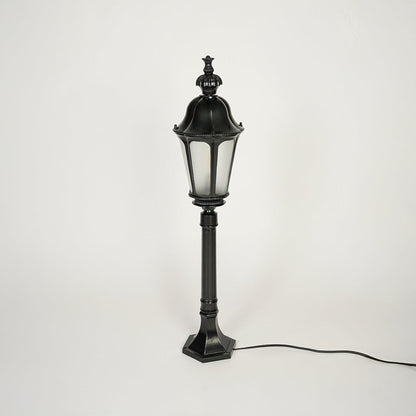 Traditional outdoor pole light with decorative top and black metal body on clean background ideal for garden or patio lighting.