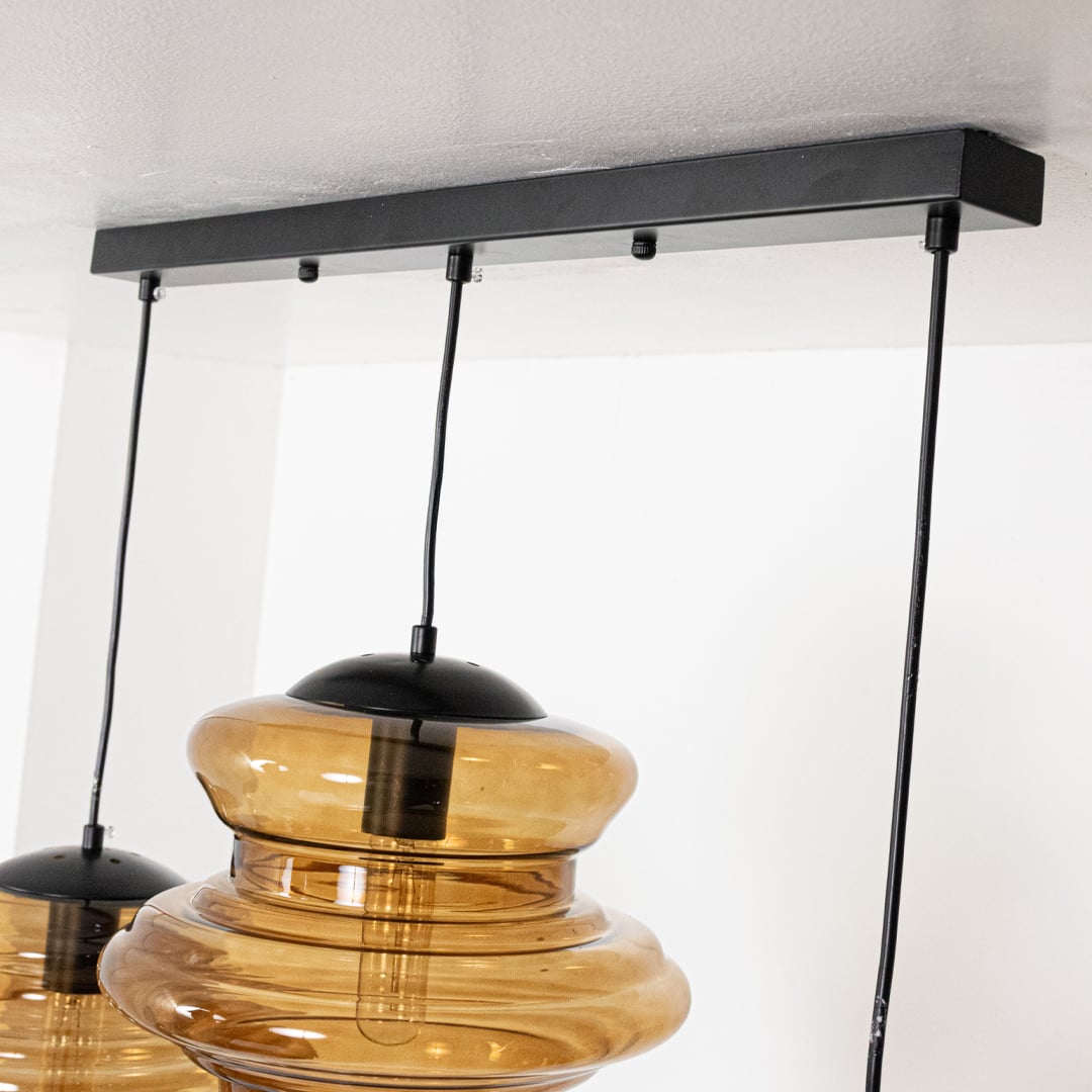 Closeup of amber ribbed glass pendant light highlighting layered texture and premium craftsmanship.