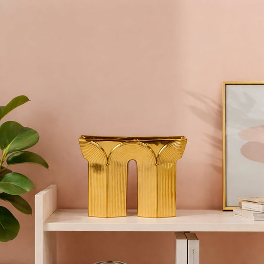 Gold metal decorative sculpture placed on shelf modern designer showpiece for living room console home decor styling.