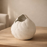 White ceramic decorative flower vase placed on wooden table minimal modern home decor styling idea.