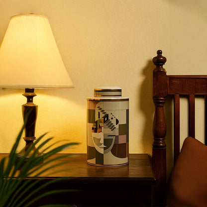 Abstract Face ceramic jar placed on a wooden bedside table next to a lamp adding a warm artistic accent to bedroom decor.