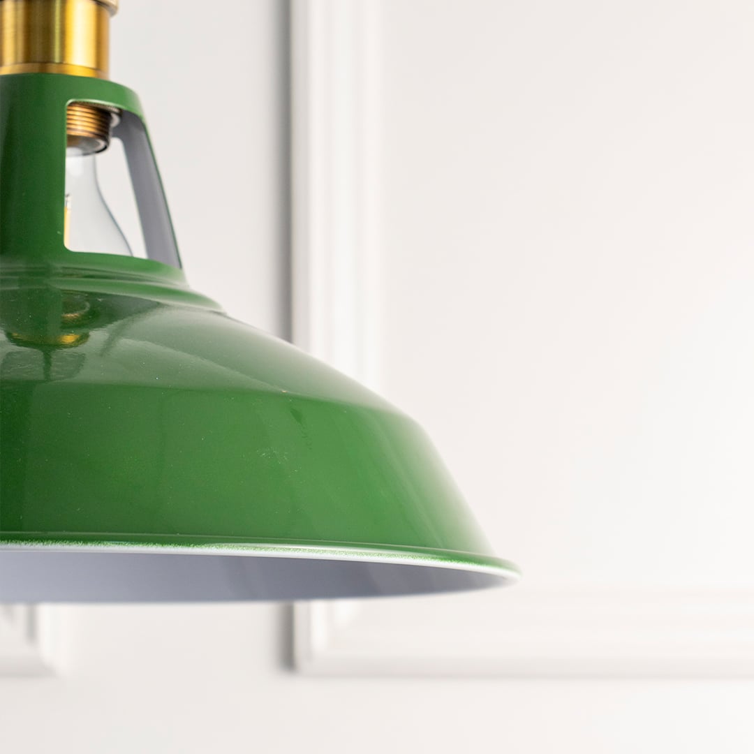 Closeup of green metal pendant light with brass accents highlighting smooth finish and timeless craftsmanship.