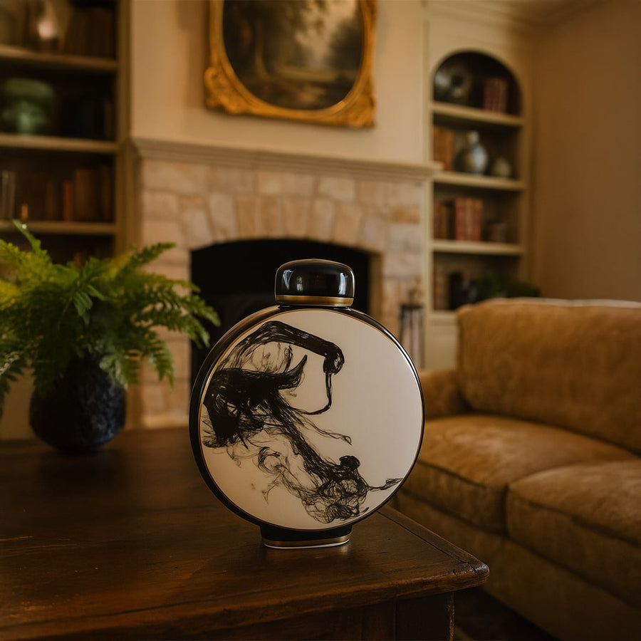 Black and white ceramic round vase with abstract ink art placed on wooden table in elegant living room interior decor.
