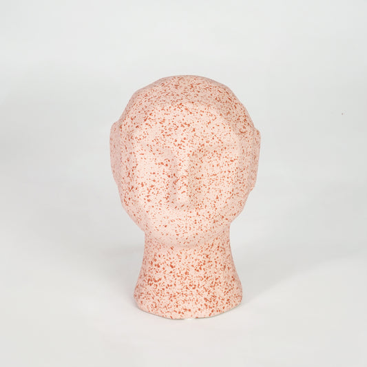 Pink textured ceramic face sculpture for modern shelf placement and artistic indoor home decor styling accent.