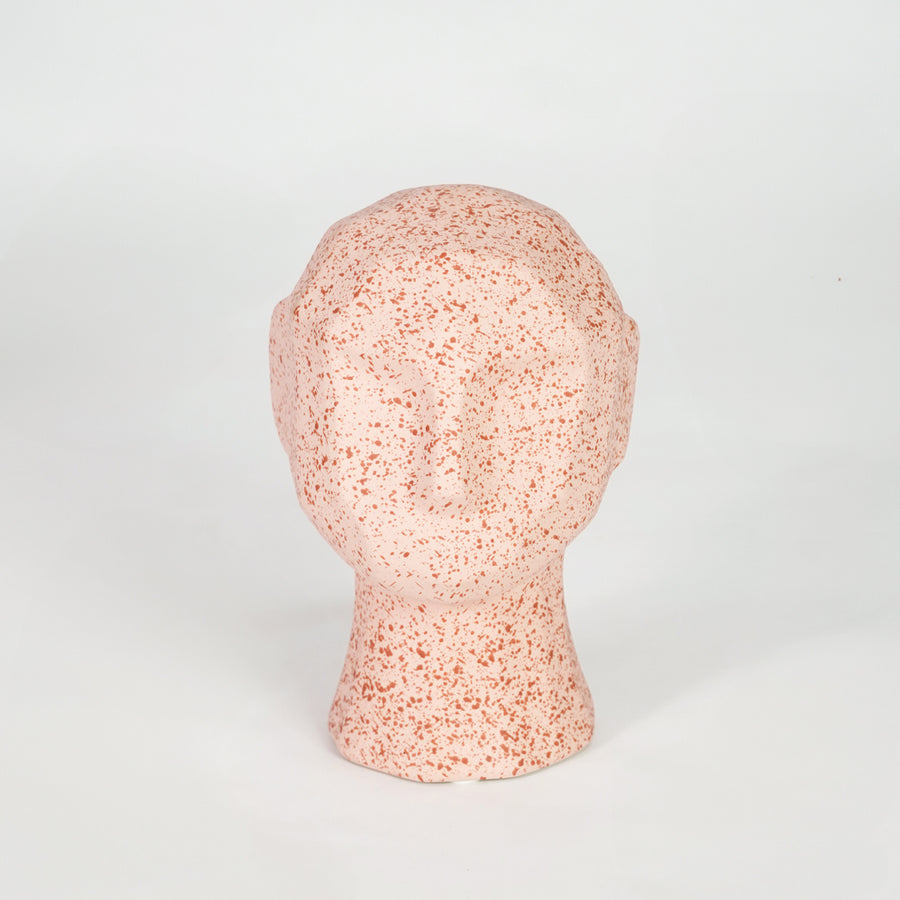 Pink textured ceramic face sculpture for modern shelf placement and artistic indoor home decor styling accent.