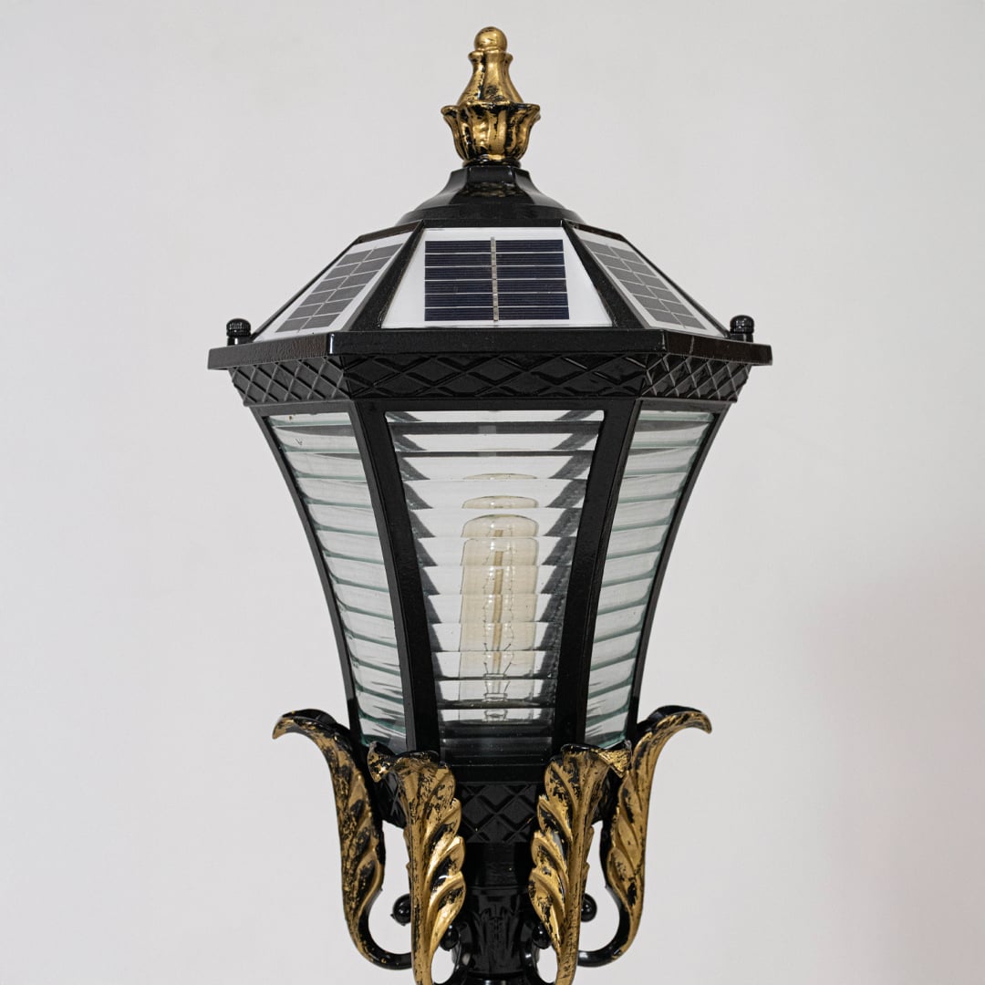 Closeup of black metal outdoor lantern light with solar panel top for elegant exterior lighting decor styling.