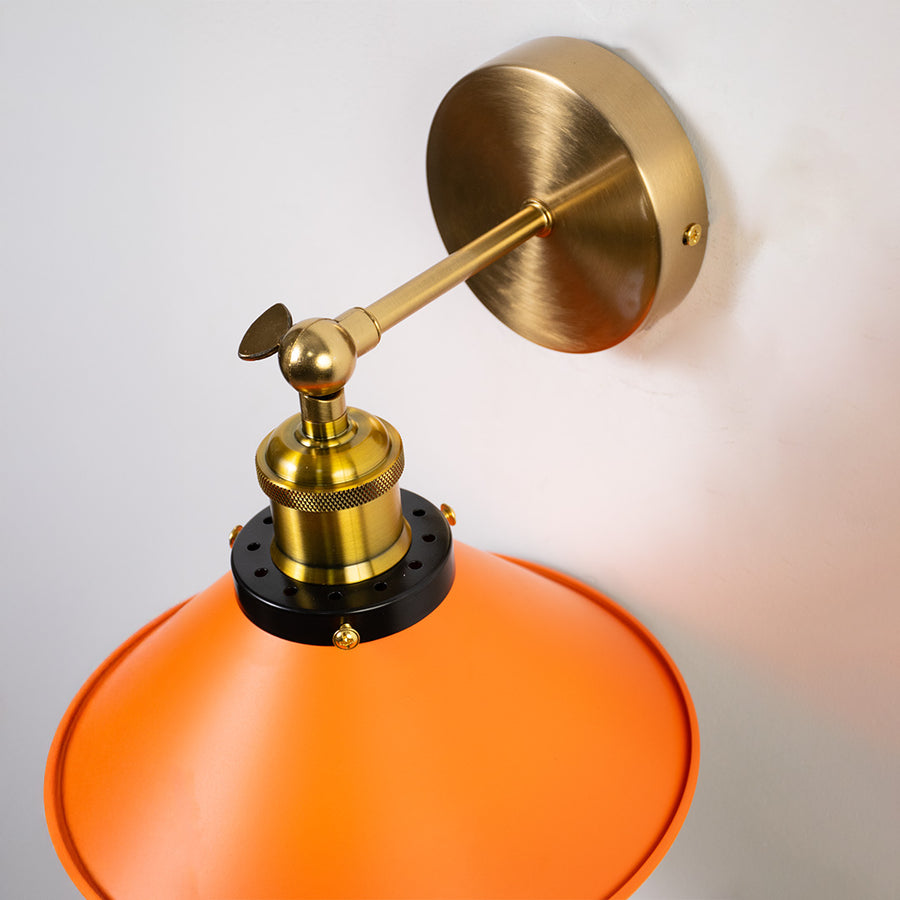Closeup of orange metal and gold wall light for modern bedroom hallway and luxury decor styling spaces.