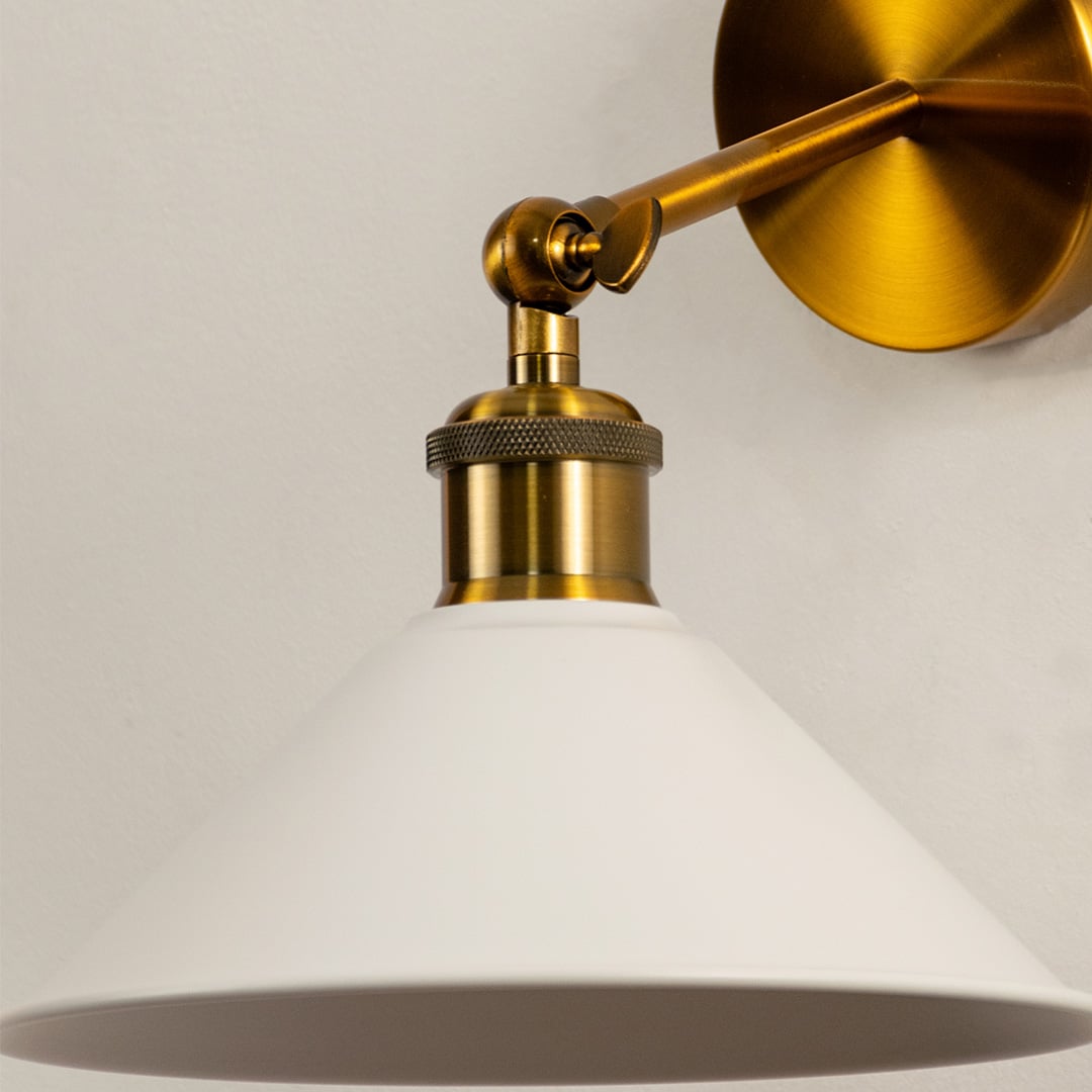 Closeup of white glass and gold metal wall light for elegant bedroom hallway and modern decor styling spaces.

