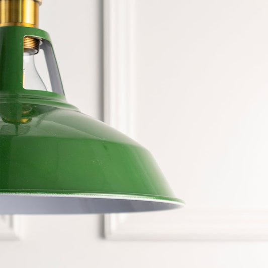 Closeup of green metal pendant light with brass accents highlighting smooth finish and timeless craftsmanship.