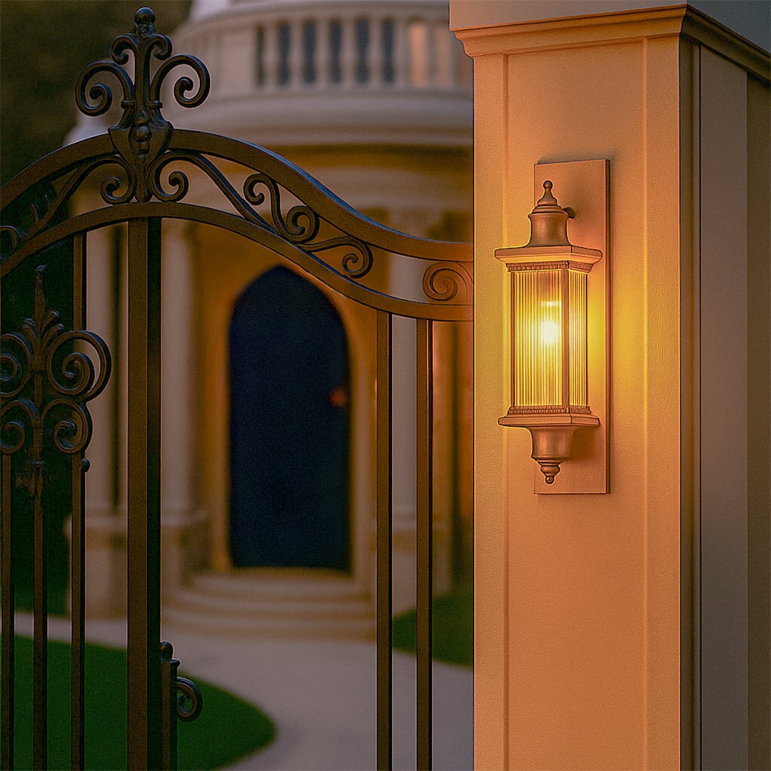 Antique bronze outdoor wall lantern lifestyle image illuminating a warm light on a gate pillar placement for decor.
