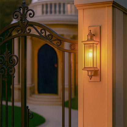 Antique bronze outdoor wall lantern lifestyle image illuminating a warm light on a gate pillar placement for decor.