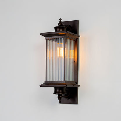 Black metal outdoor wall light on white background with ribbed glass shade for elegant exterior wall decor.
