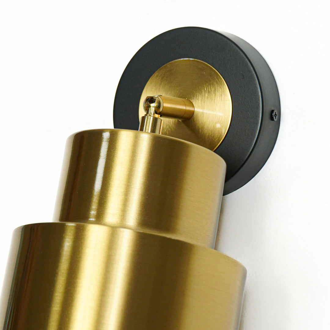 Close up gold metal wall spotlight with black base modern decorative wall lamp for bedroom living room lighting.

