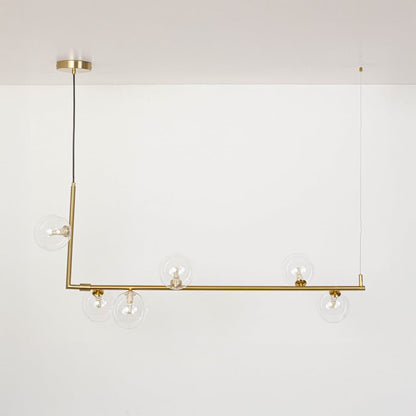 Gold linear chandelier with clear glass globes displayed on a white background with lights off showing clean form.