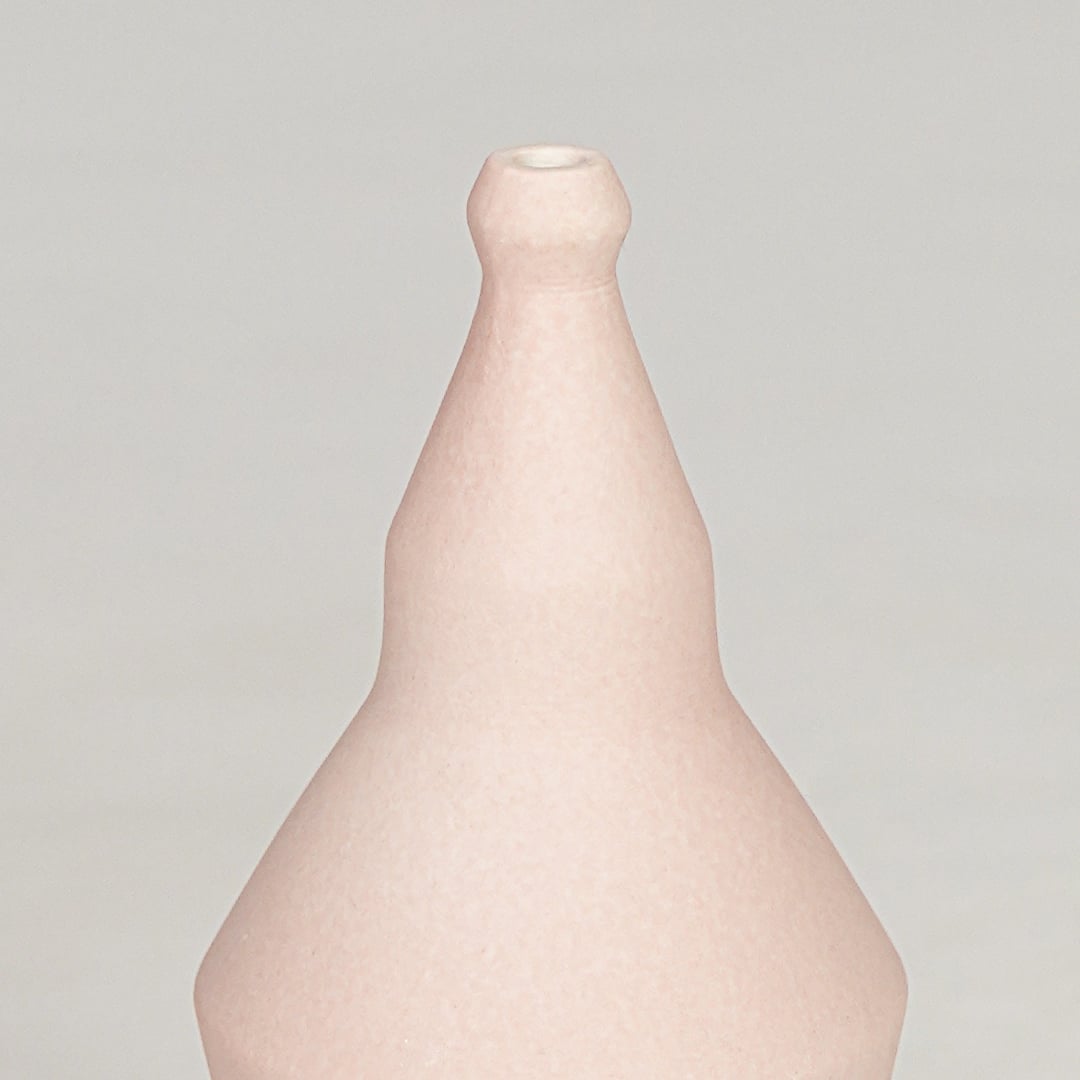 Pink ceramic decorative vase closeup with smooth finish modern flower vase for shelf console home decor styling.