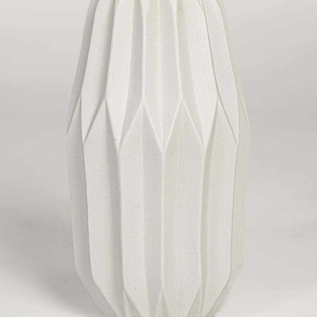 Close view of white ceramic flower vase featuring vertical sculpted pattern and smooth matte finish.