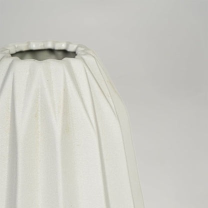 Close view of white ceramic flower vase highlighting vertical sculpted design and smooth matte finish.