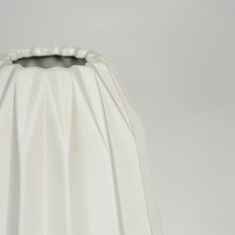 Close view of white ceramic flower vase highlighting vertical sculpted design and smooth matte finish.