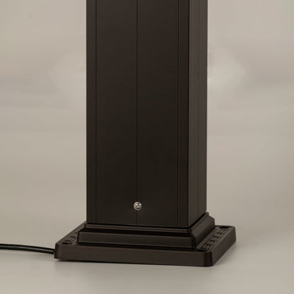 A detailed look at the lamp’s upper section highlighting the decorative finial the sloped roof and the geometric frame design surrounding the frosted glass panel.