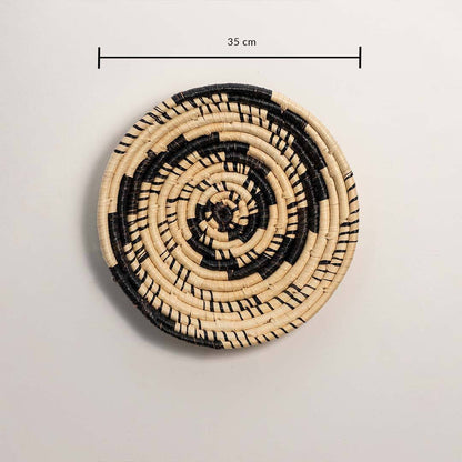 Dimension image of handcrafted black cream seagrass wall basket with swirling vortex spiral pattern for bohemian wall decor.
