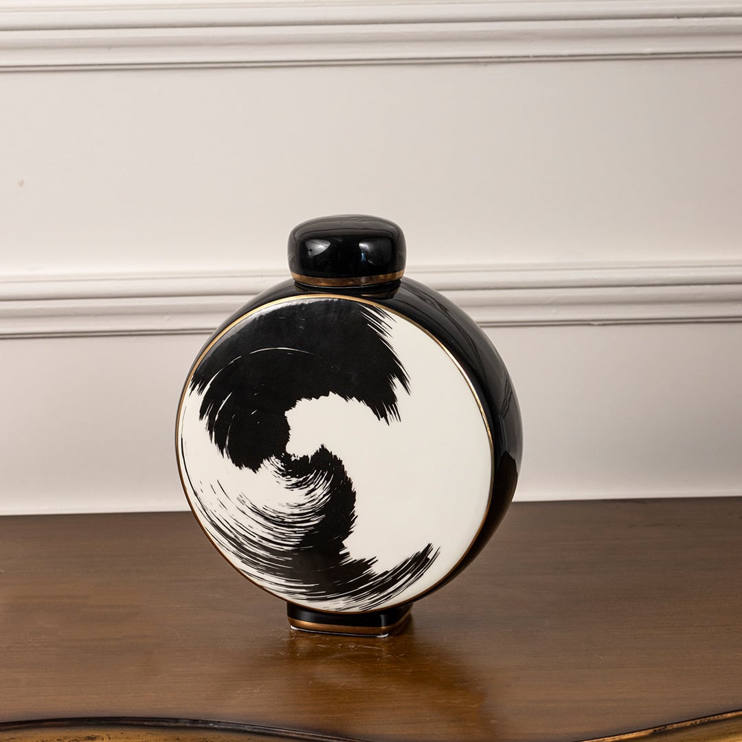 Circular ceramic decorative jar on white background highlighting bold black brushstroke design for modern artistic interior decor.