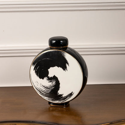 Circular ceramic decorative jar on white background highlighting bold black brushstroke design for modern artistic interior decor.