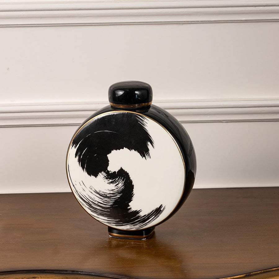 Circular ceramic decorative jar on white background highlighting bold black brushstroke design for modern artistic interior decor.