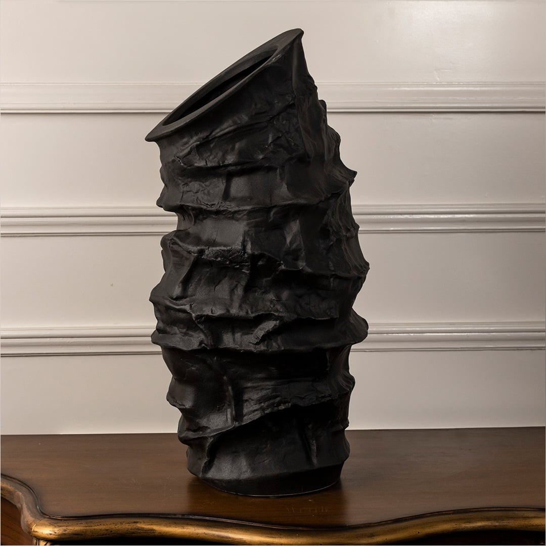 Eclipse black ceramic vase displayed on a plain white background showcasing its handcrafted textured surface and tall sculptural shape.