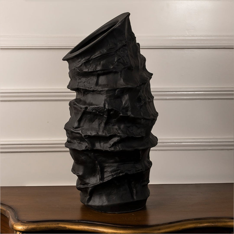 Eclipse black ceramic vase displayed on a plain white background showcasing its handcrafted textured surface and tall sculptural shape.