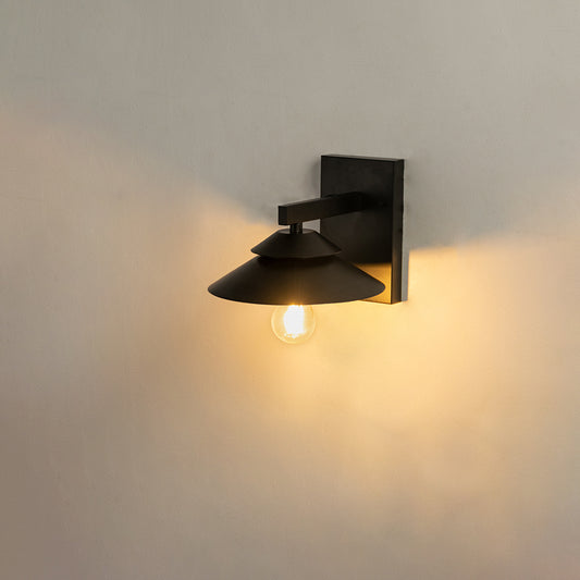 Black metal outdoor wall light on white background with warm glow for minimalist patio lighting decor.