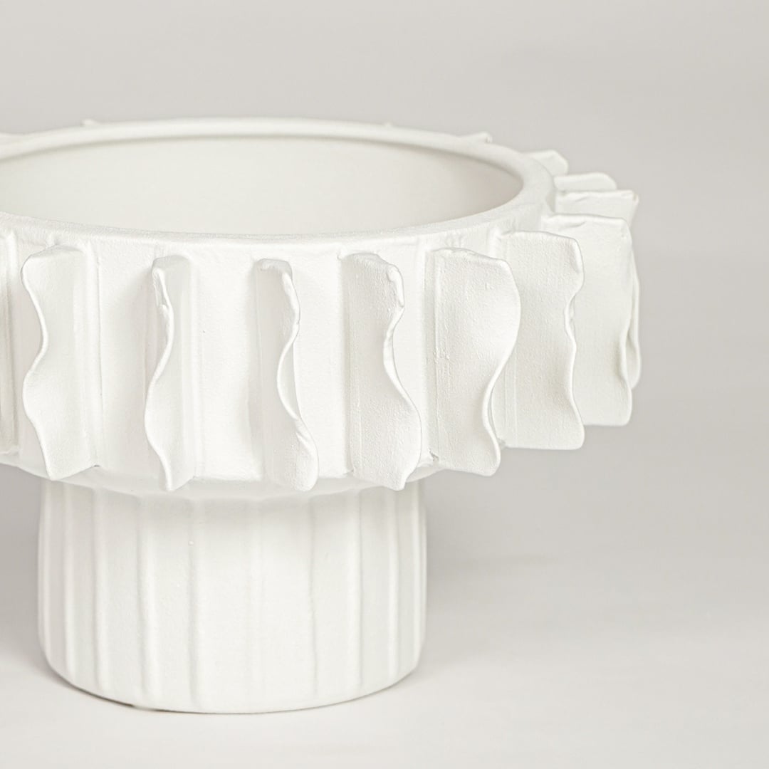 Closeup of matte white ceramic bowl vase with detailed textured rim ideal for elegant home decor shelf styling.