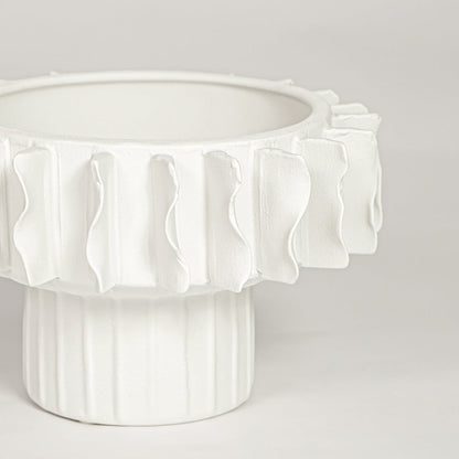 Closeup of matte white ceramic bowl vase with detailed textured rim ideal for elegant home decor shelf styling.