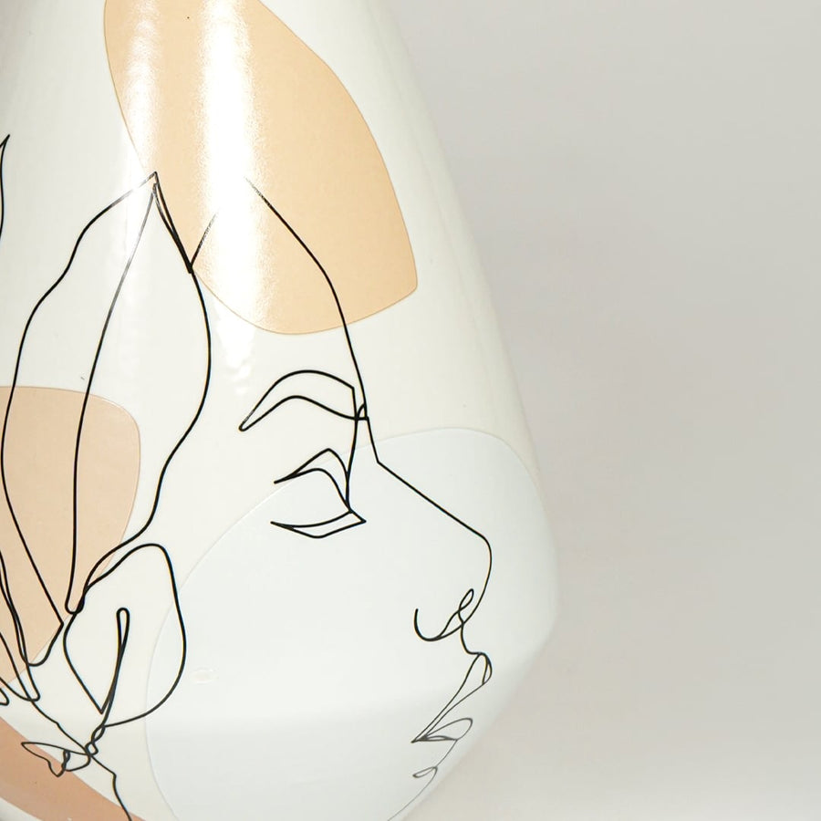 Close up view artistic ceramic vase showing minimal face illustration smooth finish decorative accent for home styling.