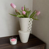 White ceramic flower vase with pink tulips for dining table console and modern home décor styling.