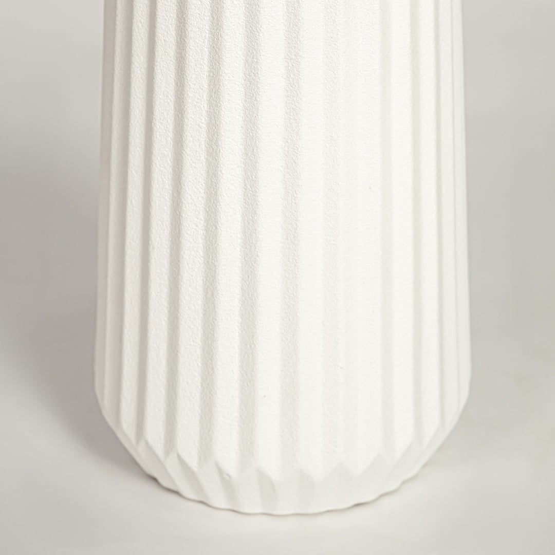 Closeup of matte white ceramic vase with fluted ribbed detailing ideal for elegant home decor shelf or side table styling.