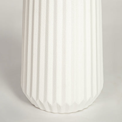 Closeup of matte white ceramic vase with fluted ribbed detailing ideal for elegant home decor shelf or side table styling.