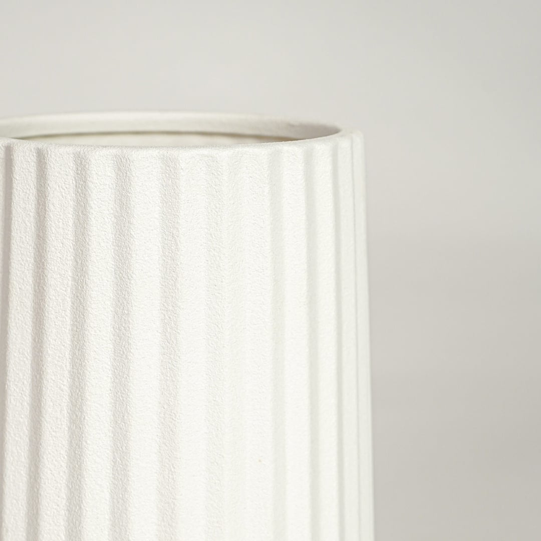 Detailed view of white ceramic flower vase with vertical grooves showcasing minimalist design for contemporary home decor styling.