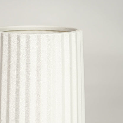 Detailed view of white ceramic flower vase with vertical grooves showcasing minimalist design for contemporary home decor styling.