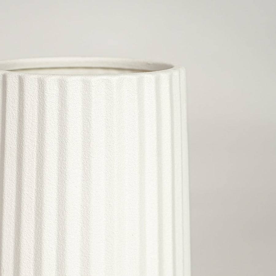 Detailed view of white ceramic flower vase with vertical grooves showcasing minimalist design for contemporary home decor styling.