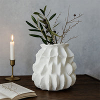 White textured ceramic vase with sculptural carved surface styled as modern table decor accent for living room interiors.