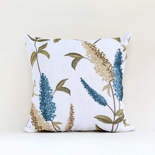 White cushion cover with blue and beige botanical print on soft fabric designed for sofa chair and bed home decor styling.