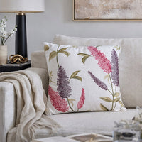 White cotton cushion cover with colorful tropical leaf print styled on a bedroom chair for vibrant modern home decor.