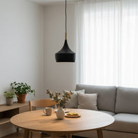Black cone pendant light with wood accent above dining table adding elegant modern ambiance.