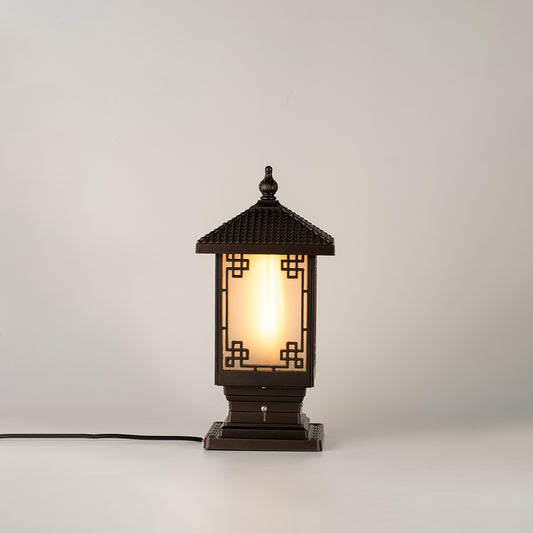 Vintage black outdoor gate light with warm glowing glass panels for elegant exterior decor use.