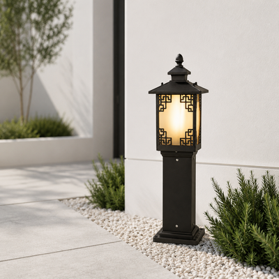 Traditional black metal ornate patterned glass pillar post lantern on white pebble path for contemporary estate entryway.