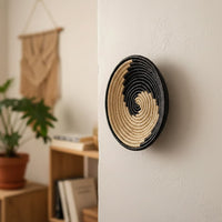Black and natural woven wall basket displayed above a console table for stylish bohemian wall decor and home interiors.