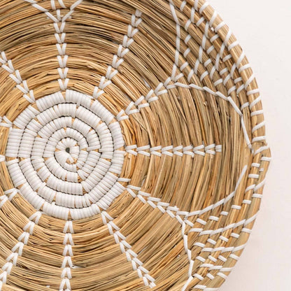 Handwoven seagrass wall basket decor showcasing intricate white spiral weave and natural fiber texture with artisan craftsmanship.