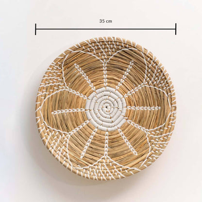 Handwoven seagrass round wall basket decor in natural beige with white spiral woven pattern and size guide on white.